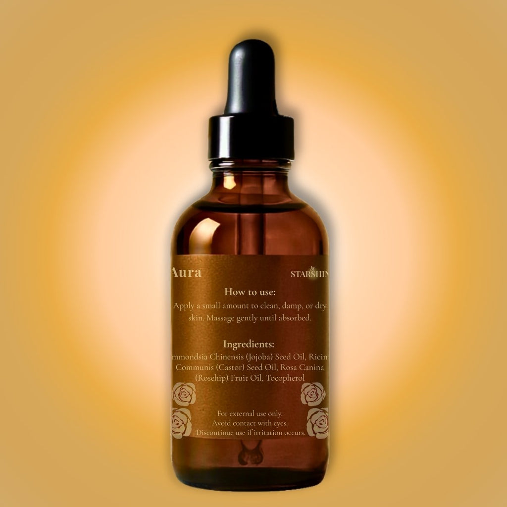 An amber glass dropper bottle of Aura byStarshine facial oil with a black dropper cap, set against a warm yellow and orange gradient background.