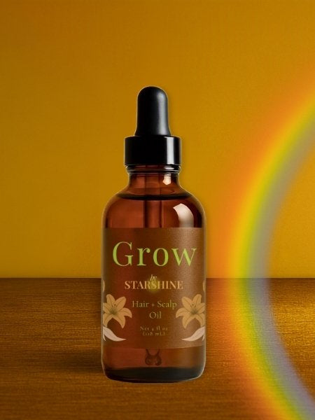 brown bottle of hair oil that says "grow" with a rainbow beside it and a brown background