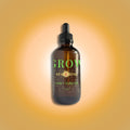 Bottle of 'GLOW Starshine' rich body oil on a gradient orange background